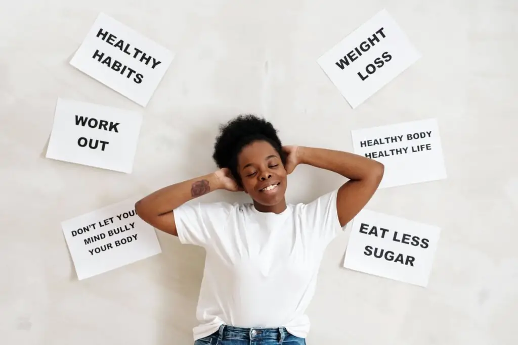 Smiling woman embracing positive lifestyle with healthy living messages around her.